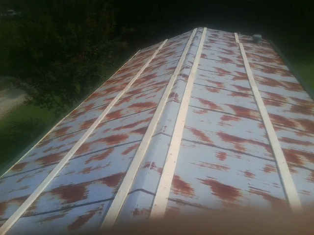 Rusted metal roof panels with new wood purlins before replacement — Storm Damage Roof Repair in Ligonier by Roofing Brothers